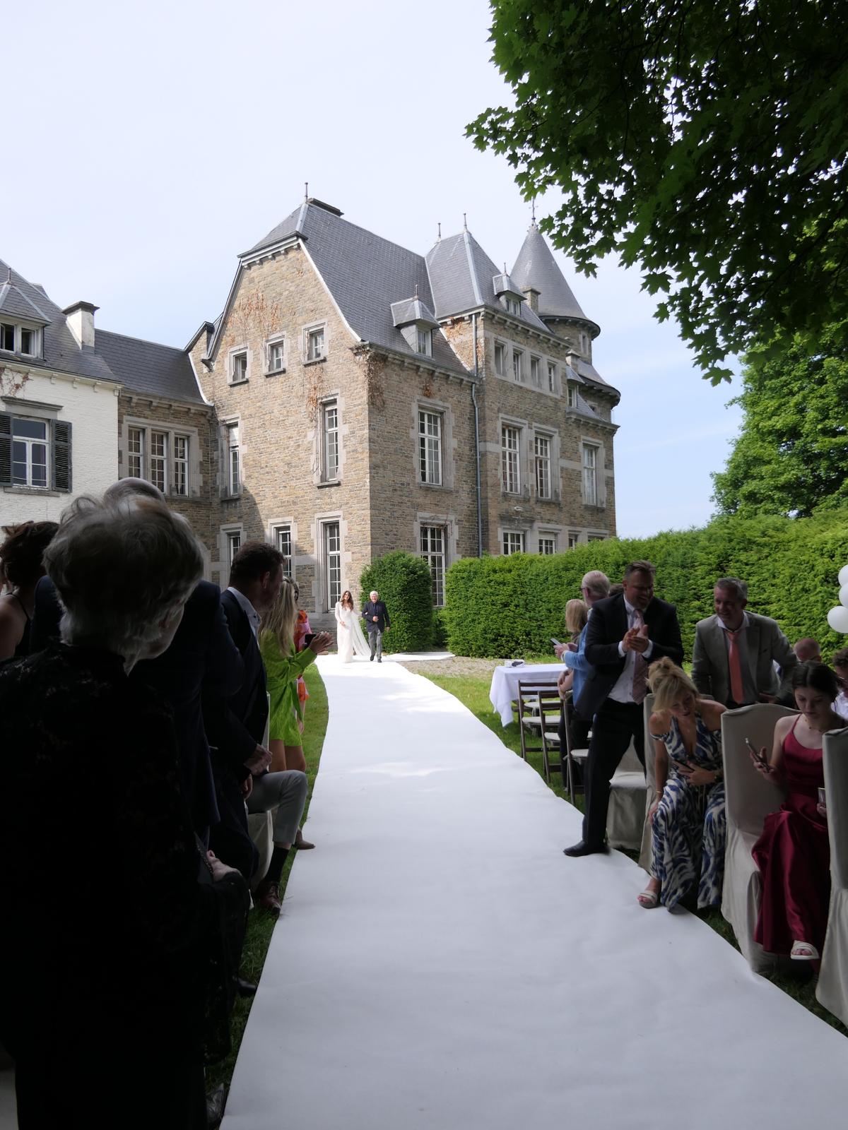 A white aisle where the bride and groom parade, surrounded by their guests, in the garden of the Château de Blier.