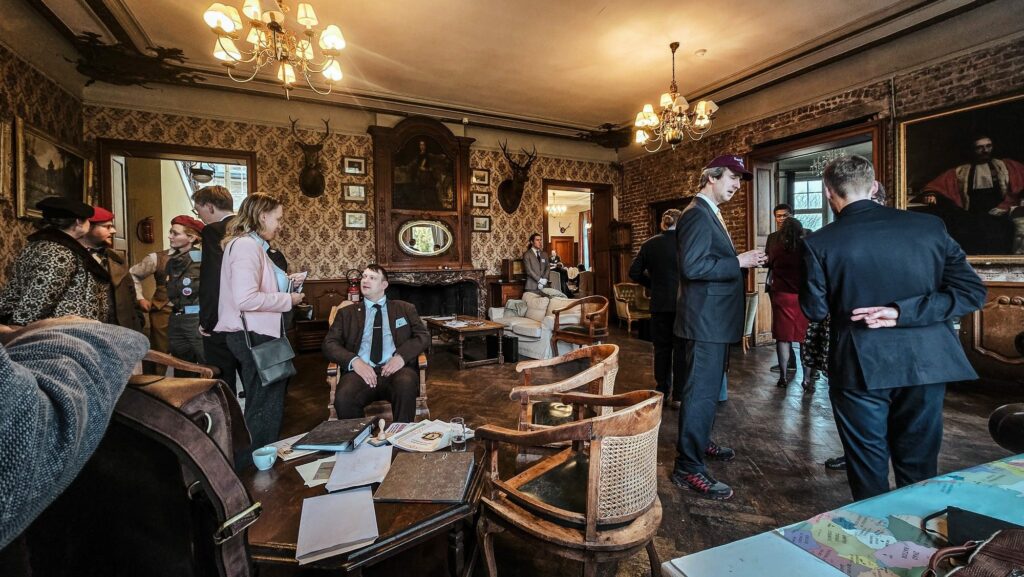 Uw verblijf in het Château de Blier 2 Uw Verblijf in Château de Blier : Een scène van het evenement "Larp's & Murder" in kasteel Blier, met een nagespeelde historische scène in een fraai ingerichte kamer van het kasteel.